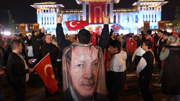 Сторонники президента Турции Реджепа Тайипа Эрдогана празднуют его победу во втором туре выборов у Президентского дворца в Анкаре