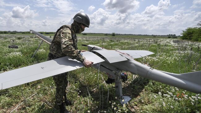 Военнослужащий ВС РФ готовит к запуску беспилотный летательный аппарат Орлан-30 в зоне проведения спецоперации