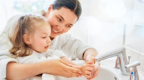 Мама с дочкой моют руки