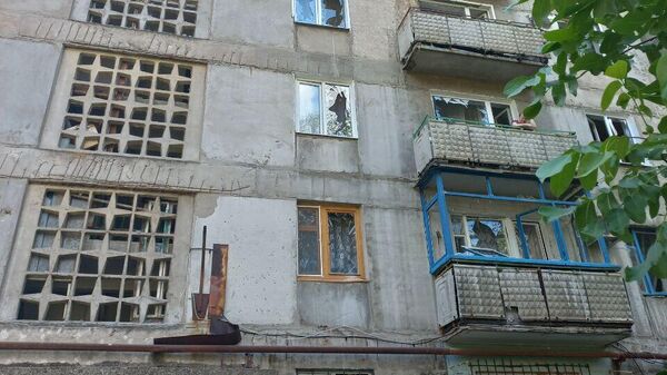 Последствия попадания снаряда ВФУ во двор многоэтажного дома в Горловке