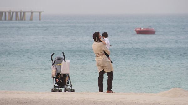 Женщина с ребенком на пляже на острове Киш, южный Иран