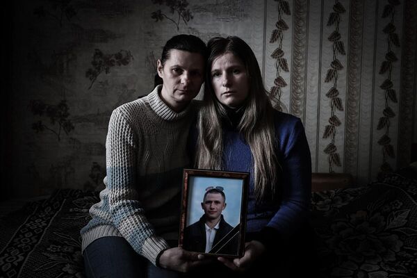 Жительницы города Стаханов  с портретом недавно погибшего близкого человека. ЛНР, 2022