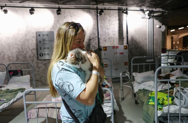 Девушка с кошкой в пункте временного размещения жителей, организованном на территории стадиона Белгород-Арена в связи с массированными обстрелами Шебекинского городского округа с украинской стороны