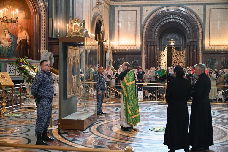 Священнослужители у иконы Святой Троицы перед началом патриаршего служения по случаю принесения иконы в храм Христа Спасителя в Москве