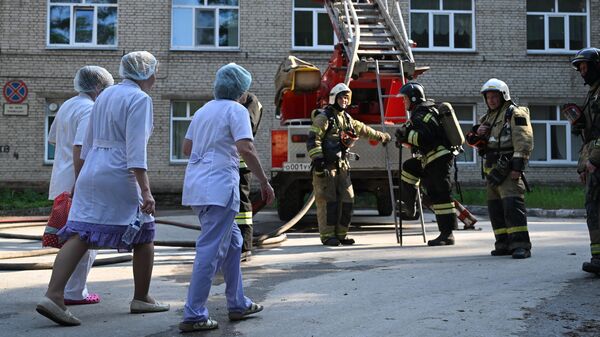 Пожарные и эвакуированный медперсонал во время тушения пожара в здании Центральной клинической больницы в Новосибирске