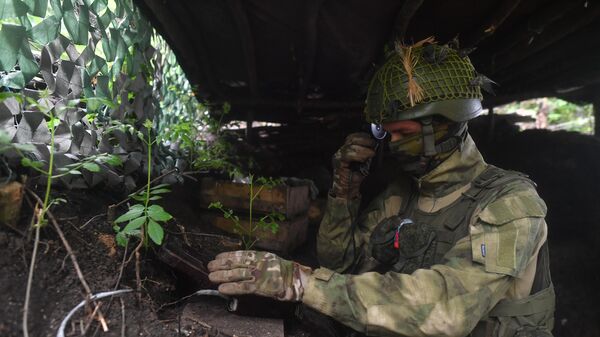 Военнослужащий ВС РФ разговаривает по полевому телефону в зоне проведения СВО