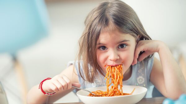 Девочка ест спагетти