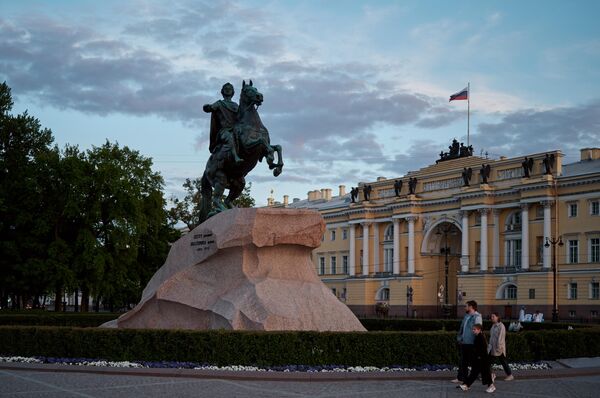 Люди проходят мимо памятника первому российскому императору Петру Великому Медный всадник на Сенатской площади во время белых ночей в Санкт-Петербурге