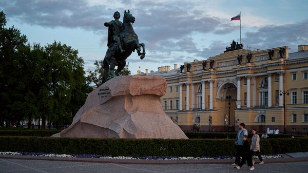 Люди у памятника первому российскому императору Петру Великому (Медный всадник) на Сенатской площади во время белых ночей в Санкт-Петербурге