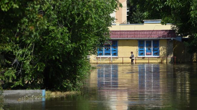 Местная жительница на одной из подтопленных улиц в Новой Каховке после разрушения Каховской ГЭС