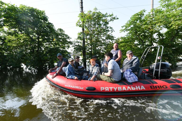 Волонтеры и спасатели МЧС проводят эвакуацию людей в городе Голая Пристань после подтопления