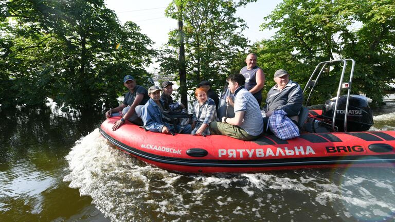 Волонтеры и спасатели МЧС проводят эвакуацию людей в городе Голая Пристань после подтопления