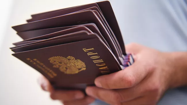 Российские паспорта в руках мужчины