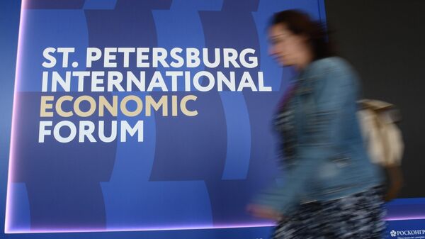 Женщина проходит мимо логотипа ПМЭФ-2023 в конгрессно-выставочном центре Экспофорум в Санкт-Петербурге