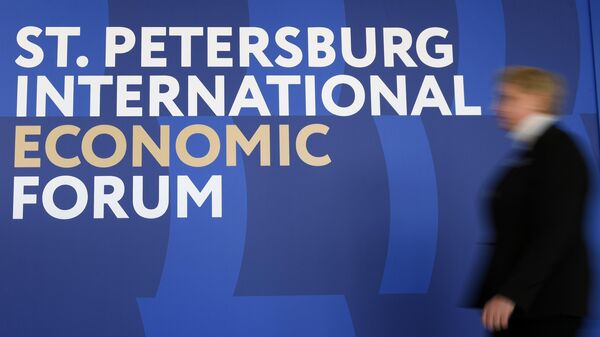 Женщина проходит мимо логотипа ПМЭФ-2023 в конгрессно-выставочном центре Экспофорум в преддверии Петербургского международного экономического форума - 2023 в Санкт-Петербурге