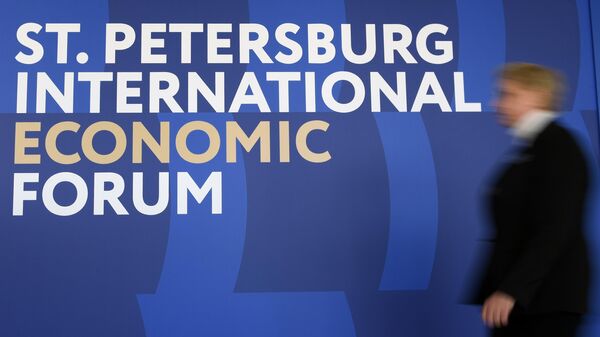 Женщина проходит мимо логотипа ПМЭФ-2023 в конгрессно-выставочном центре Экспофорум в преддверии Петербургского международного экономического форума — 2023 в Санкт-Петербурге