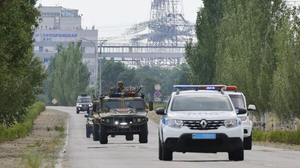 Автомобили сопровождения делегации МАГАТЭ на дороге к Запорожской атомной электростанции
