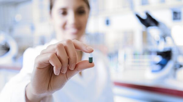 Девушка держит таблетку в лаборатории 
