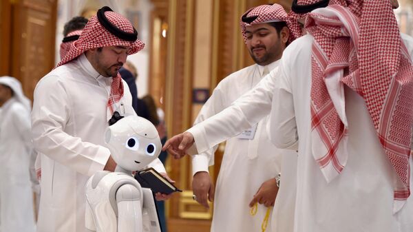 Люди возле робота в конференц-центре короля Абдулазиза в столице Саудовской Аравии Эр-Рияде