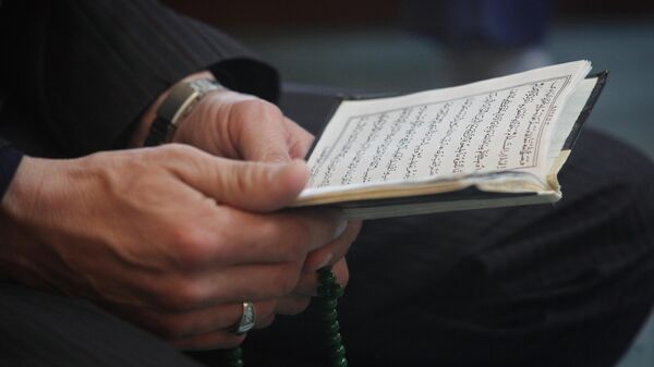 Коран в руках мусульманина