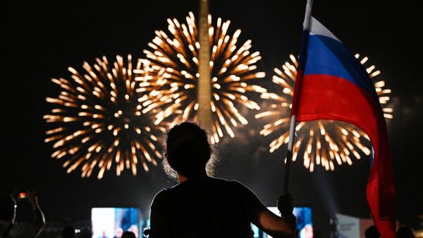 Девушка смотрит праздничный салют в честь Дня Государственного флага России на Поклонной горе в Москве