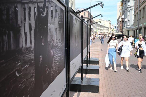 Прохожие на Арбате в Москве, где открылась выставка победителей Всероссийского конкурса военной фотожурналистики