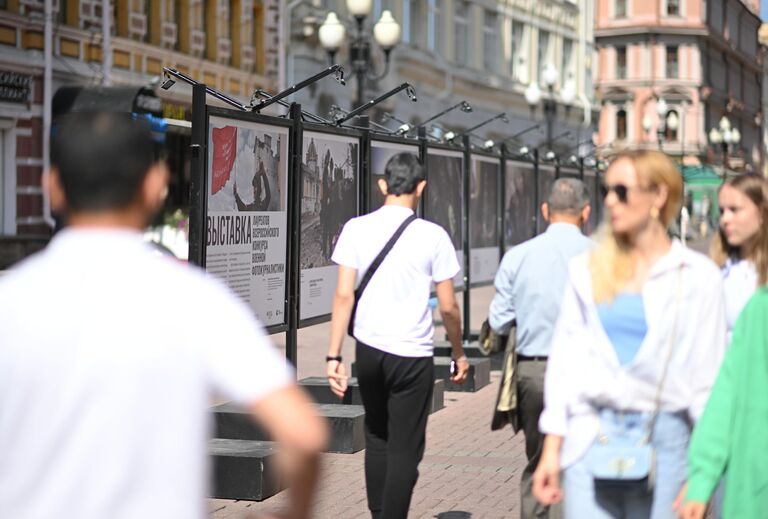 Прохожие на Арбате в Москве, где открылась выставка победителей Всероссийского конкурса военной фотожурналистики