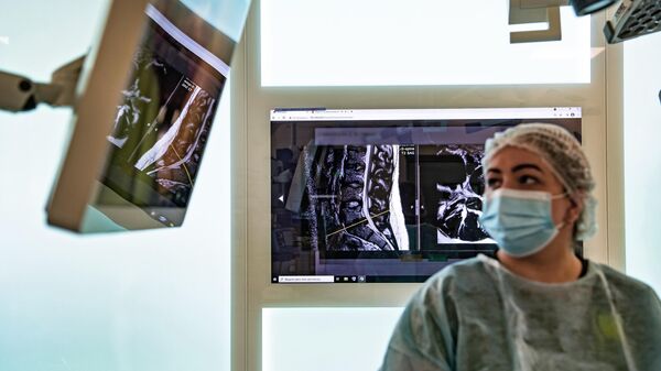 Медицинский работник рассматривает снимки во время операции в интегрированной эндоскопической 3D-операционной московского спинального центра ГКБ № 67 им. Л. А. Ворохобова в Москве 