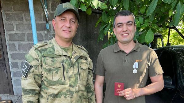 Награждение хирурга городской клинической больницы Махачкалы Магомеда Магомедова (справа) медалью За спасение погибавших
