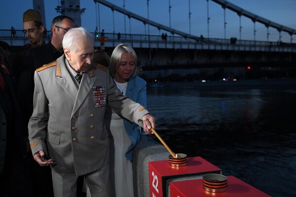 Ветеран Великой отечественной войны зажигает свечу во время  акции Линия памяти, приуроченной ко Дню памяти и скорби, на Крымской набережной в Москве