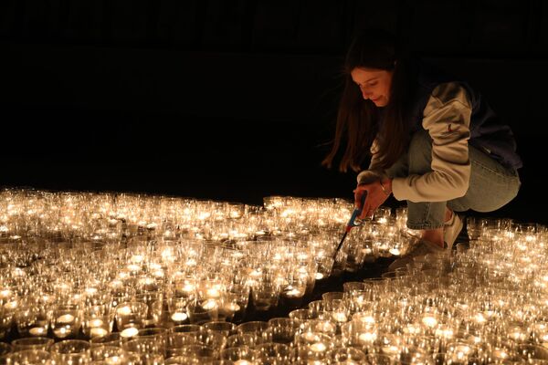 Участница международной акции Огненные картины войны, приуроченной ко Дню памяти и скорби, зажигает свечи на территории Мемориального комплекса Саур-Могила