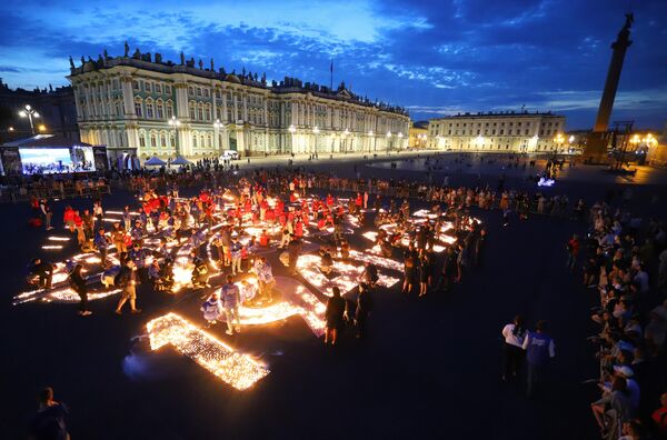 Участники акции Свеча памяти, приуроченной ко Дню памяти и скорби, зажигают свечи на Дворцовой площади в Санкт-Петербурге