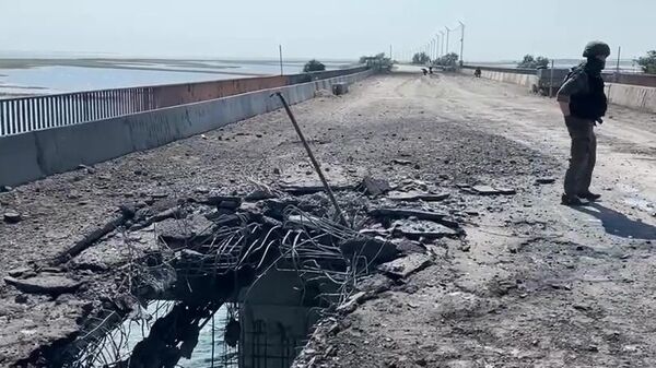 Сотрудник Следственного комитета России на поврежденной дороге на Чонгарском мосту. Кадр видео