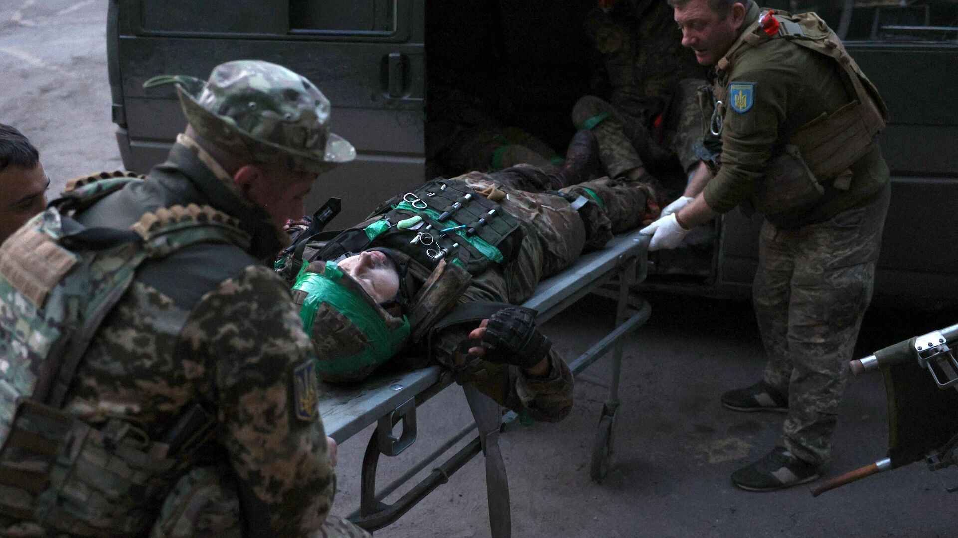 Украинские военные медики несут раненого военнослужащего, доставленного с передовой - РИА Новости, 1920, 23.06.2023