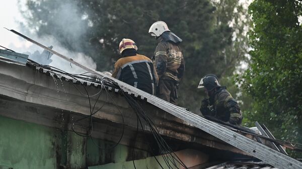 Сотрудники пожарной службы МЧС РФ работают на месте пожара