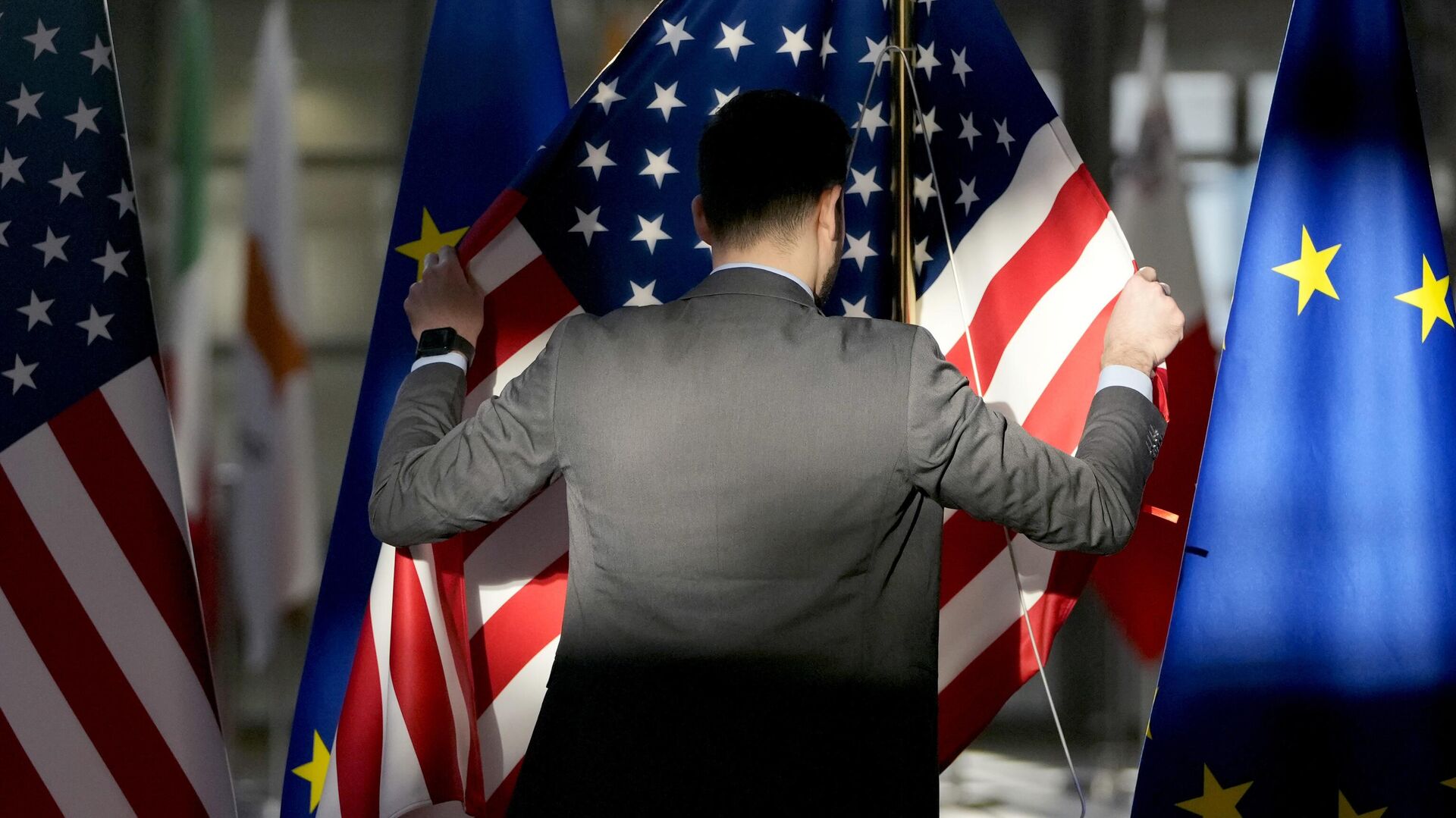 Сотрудник поправляет флаги США и ЕС в здании Европейского совета в Брюсселе - РИА Новости, 1920, 18.11.2023