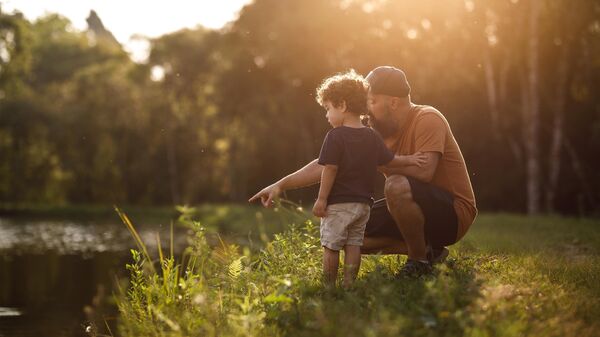 Ребенок с отцом на природе у озера