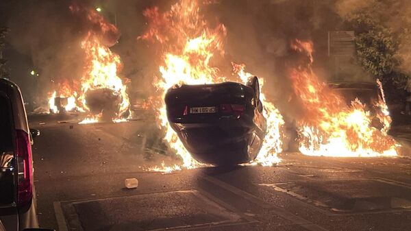 Горящие автомобили во время беспорядков во французском Нантере