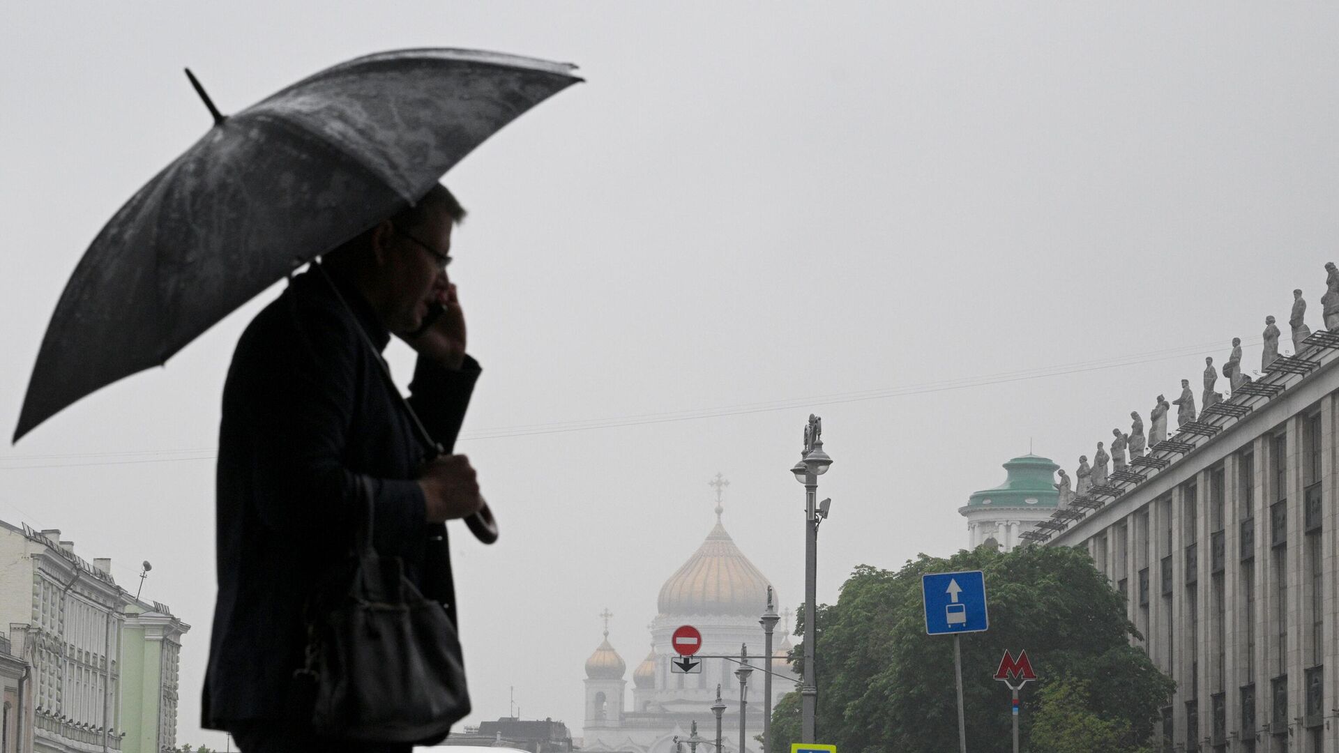 Мужчина с зонтом в дождливую погоду на одной из улиц в Москве - РИА Новости, 1920, 26.07.2023