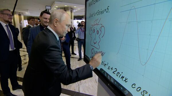 Путин рисует на интерактивном экране во время посещения выставки форума АСИ