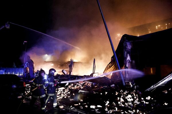 Пожарные тушат пламя здания, подожженного во время протестов в Рубе, на севере Франции, 30 июня 2023 года