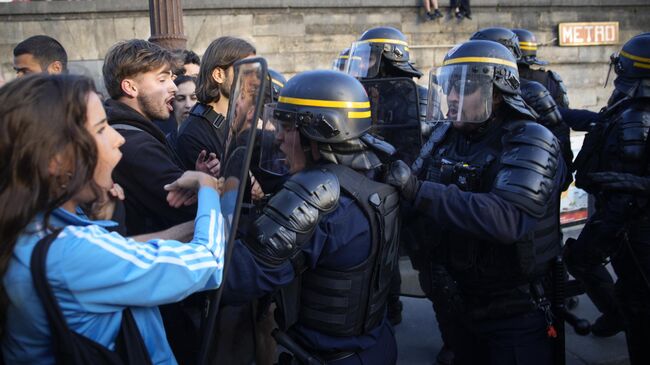 Участники протеста и сотрудники правоохранительных органов на одной из улиц в Париже