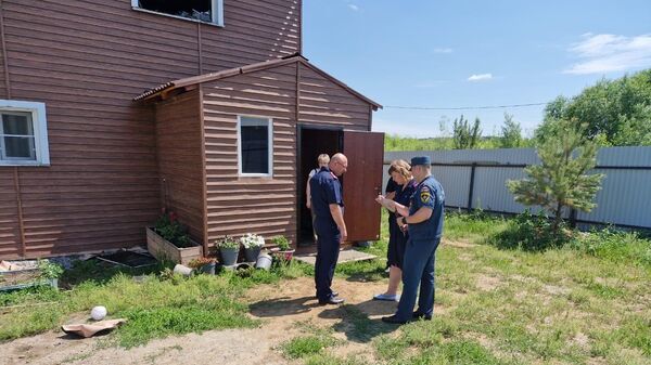Сотрудники правоохранительных органов на месте пожара в частном доме в Хабаровске