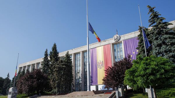 Приспущенные флаги на фасаде здания правительства республики Молдова в Кишиневе