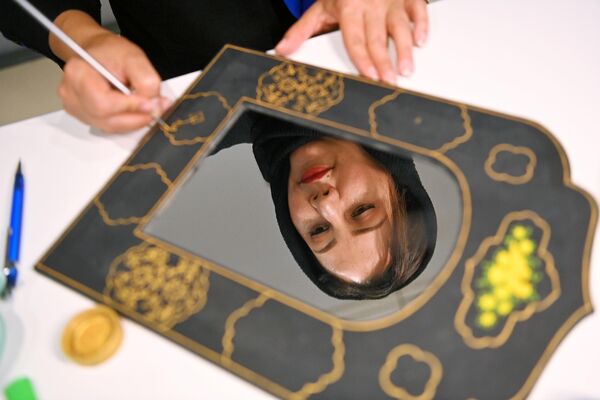 Участница выставки расписывает рамку зеркала на одном из стендов на выставке иранского искусства в рамках проекта Обменные культурные мероприятия России и Ирана на ВДНХ
