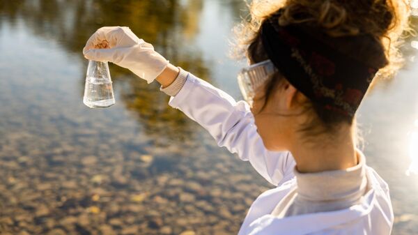 Девушка-ученый проверяет качество воды