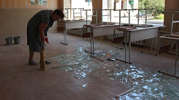 Уборка стекла из разбитых окон в классе средней школы № 8 после обстрела ВСУ города Макеевки