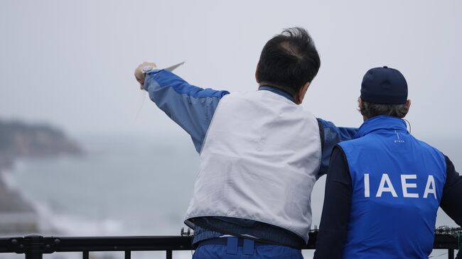 Президент Tokyo Electric Power Co. Томоаки Кобаякава и глава МАГАТЭ Рафаэль Гросси обсуждают вопросы сброса воды с атомной электростанции Фукусима