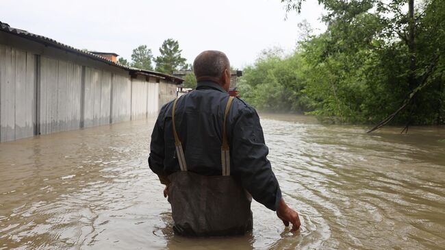 Мужчина на затопленной улице в Иркутской области