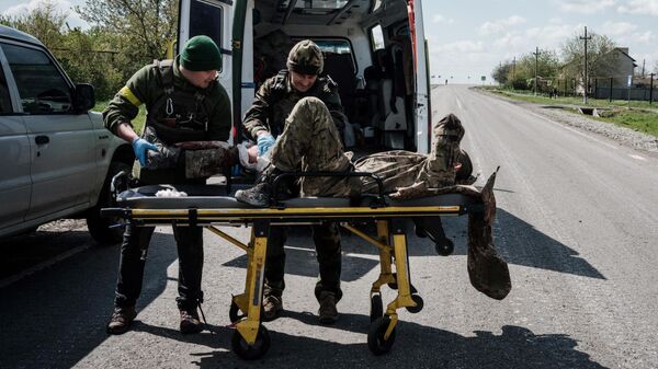 Украинские военнослужащие эвакуируют раненного